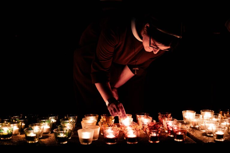 francsican nun lighting candles for prayer